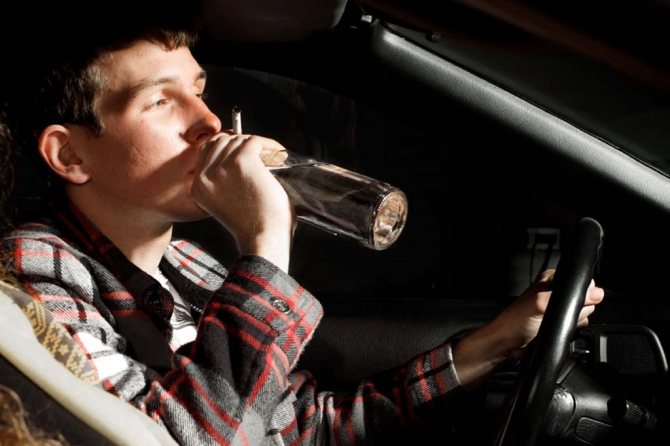 man drinks and smokes while driving