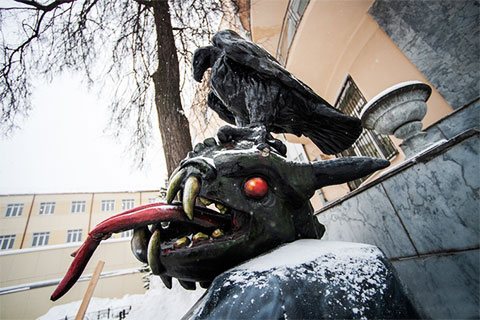 Sculpture in the courtyard of the prison - a black golden eagle holds a snake&#39;s head in its claws