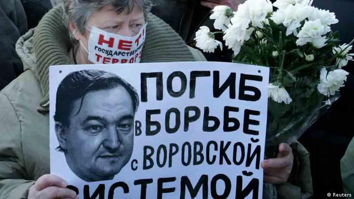 Woman with a poster with a portrait of Sergei Magnitsky
